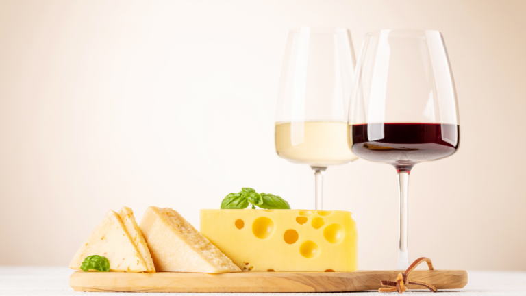 Plateau de fromage avec un verre de vin rouge et un autre de vin blanc