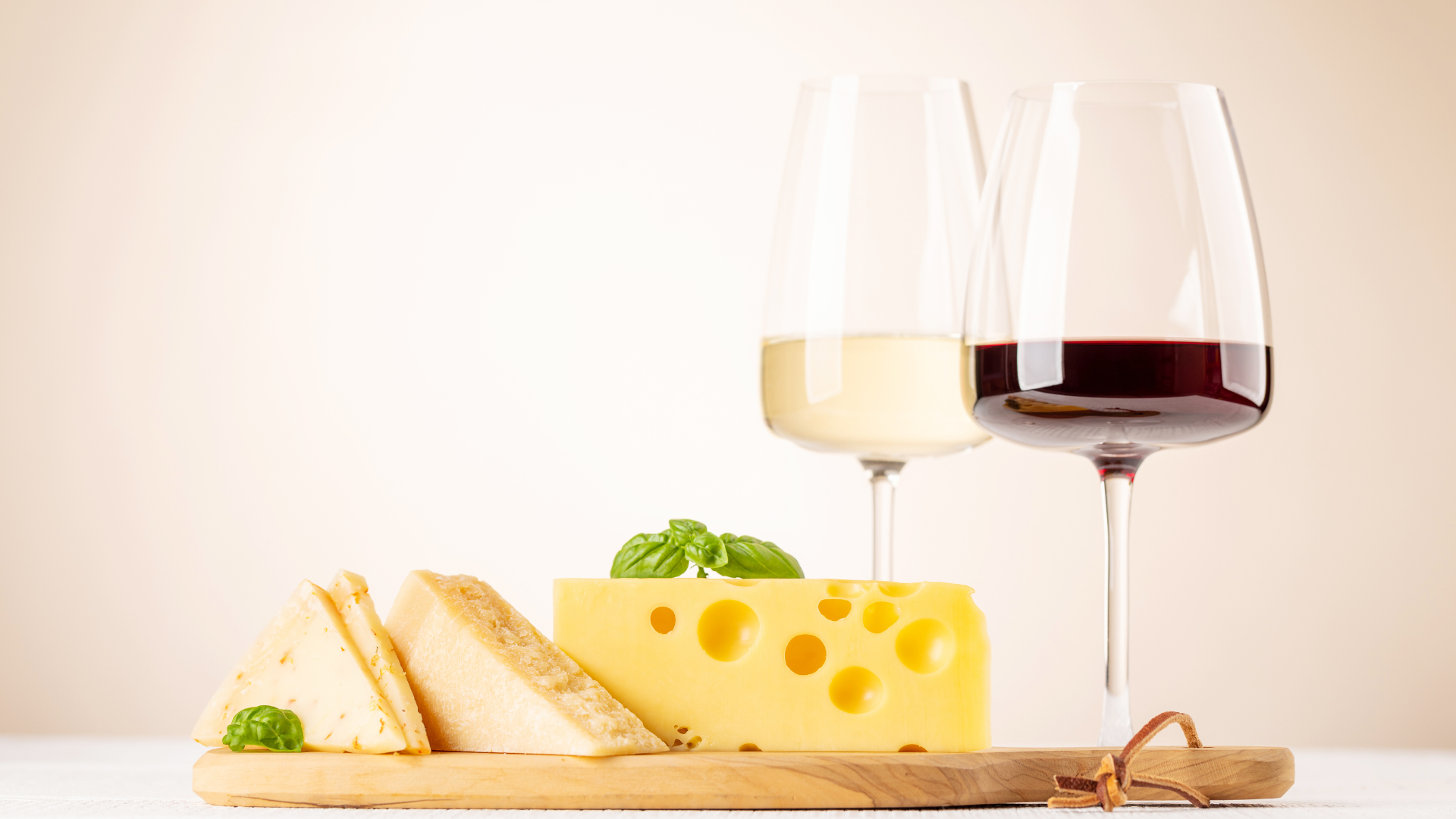 Plateau de fromage avec un verre de vin rouge et un autre de vin blanc