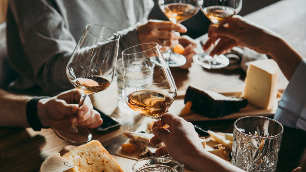 personnes qui trinquent avec du rosé et de la charcuterie, fromage